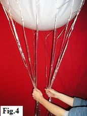 Helium filled 36 inch balloon held by the strings of a hot air balloon net.