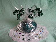 Finished balloon sand weight placed on a paper doylie, decorated with metallic confetti