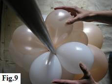 White and peach balloon clusters attached to a PVC pipe Balloon clusters attached to PVC pipe