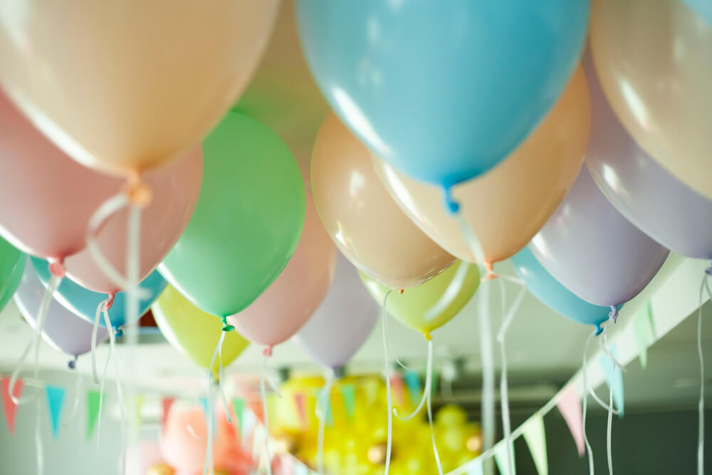 Balloon ceiling decor for a birthday party using pastel colored balloons