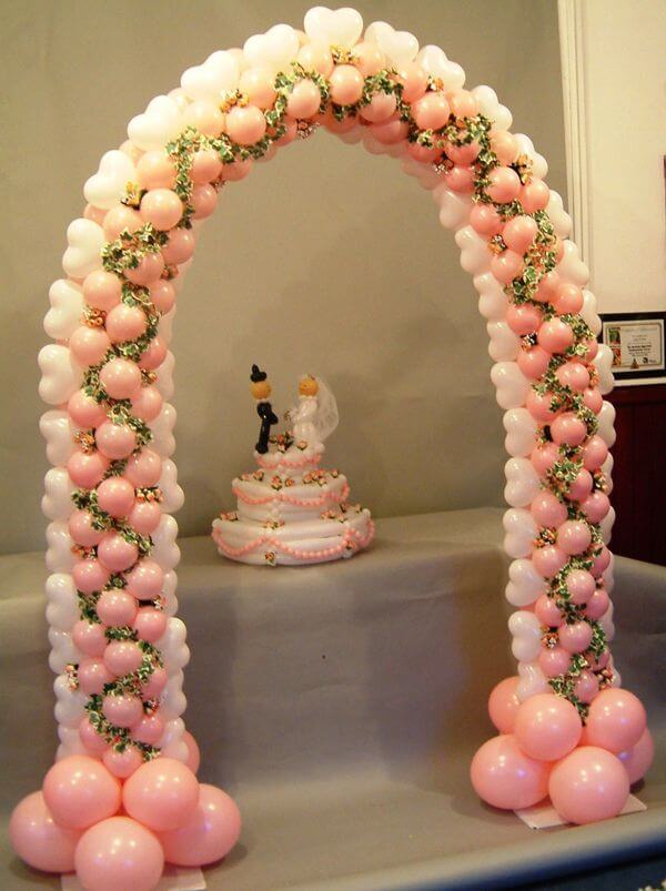 Cake table balloon arch in rose and white.
