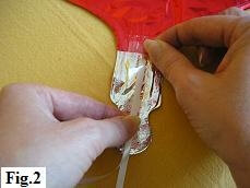 Using sticky tape to attach the ribbon to the valve of the mylar balloon. Using sticky tape to attach the ribbon to the valve of the mylar balloon.