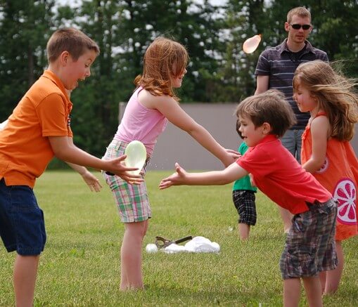 Kids playing water balloon toss