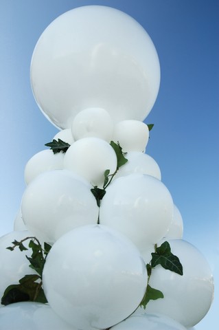 Wedding balloon column in white, decorated with green ivy leaves