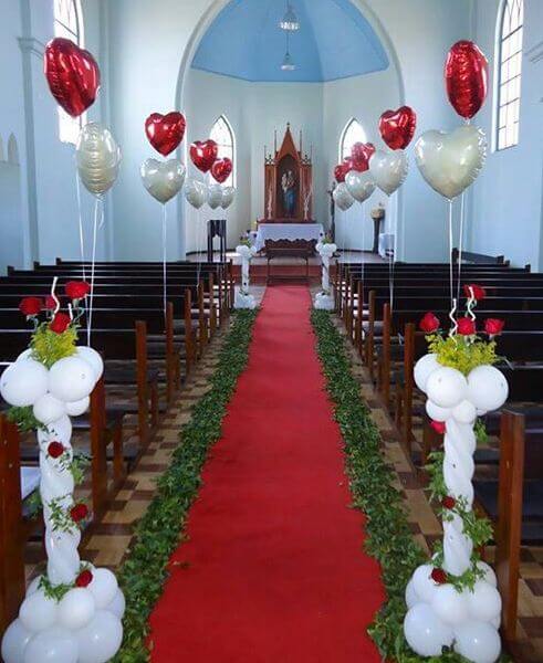 Church aisle decorated with heart shaped balloons.
