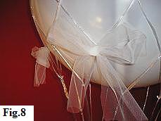 Adorning the hot air balloon net with bows of white tulle.