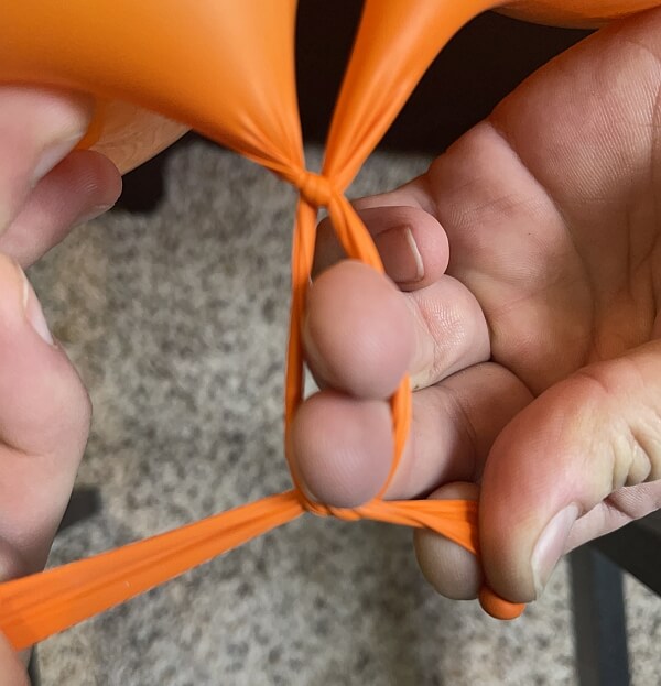 How to tie two latex balloons together to form a duplet.