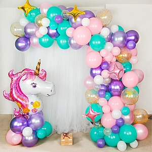 Unicorn themed organic balloon arch in pastel colors.