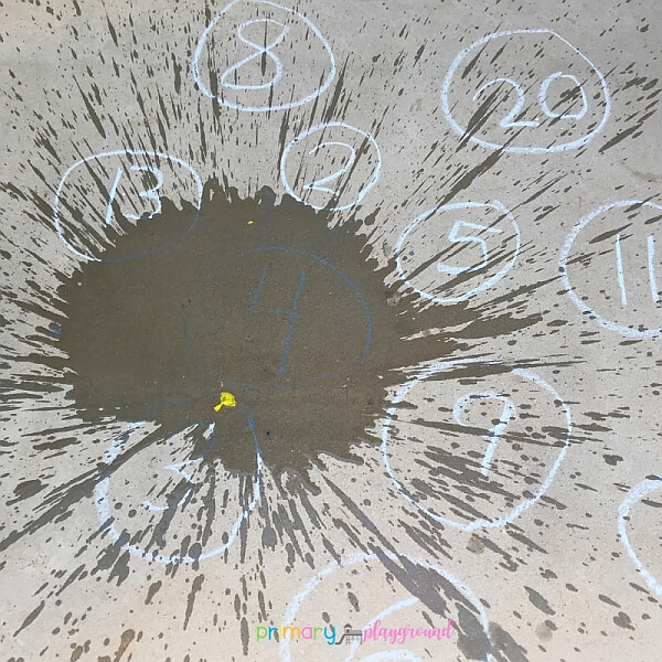 Numbers drawn with chalk on driveway to play water balloon number target practice